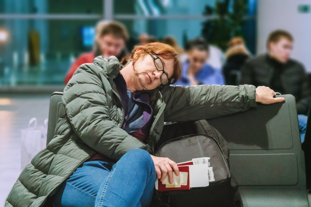 女旅客在机场睡觉，等待航班图片下载
