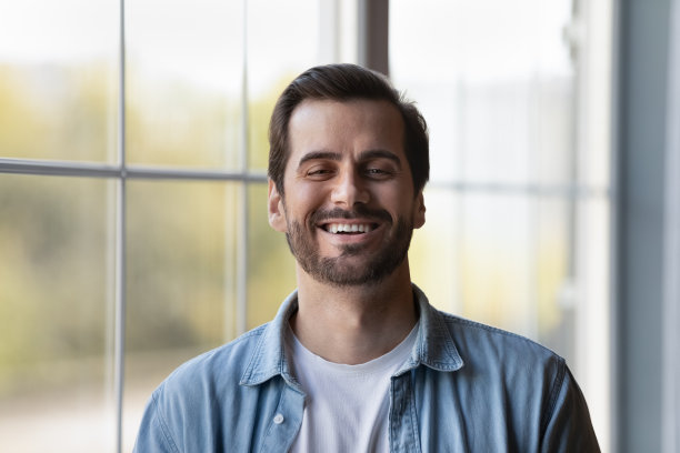 笑着站在室内的年轻随意男性的头像图片下载