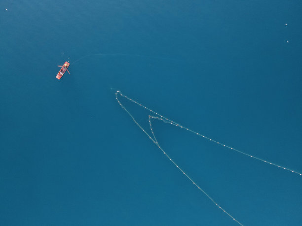 湛蓝湖水上的渔船和渔网，中国新疆图片下载