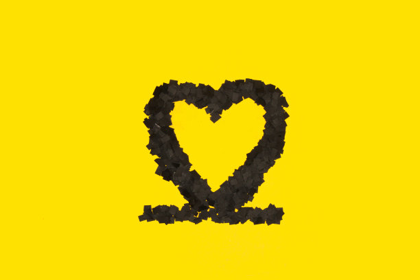 黑色的心在黄色的背景，创造性的艺术最小的设计图片下载