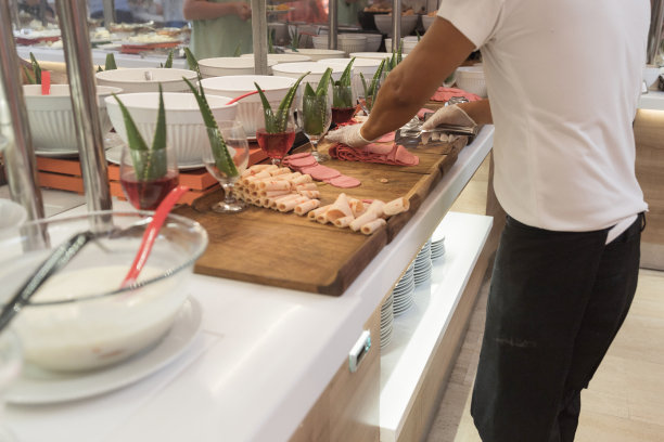 戴着防护手套的男人端着切片火腿图片下载