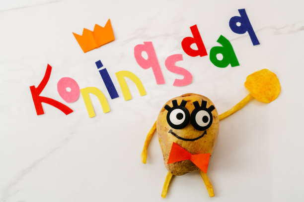 国王节是荷兰王国的一个全国性节日。有趣的土豆与眼睛和在一个领带的背景铭文科宁斯达图片下载