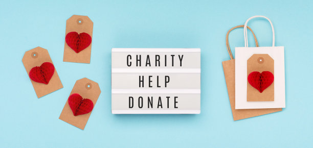 红色的纸心，蓝色背景的白色灯箱。9月5日是国际慈善日。图片下载