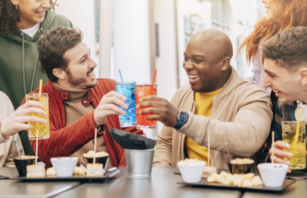 快乐的多种族朋友在餐厅聚会上举杯、喝酒、吃饭图片下载