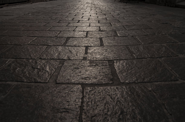 对称图像的深灰色鹅卵石。光线落在人行道的中间图片下载