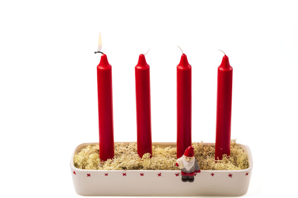 近距离的传统烛台充满苔藓燃烧一根红色的蜡烛，以纪念第一次来在白色的背景。瑞典。图片下载