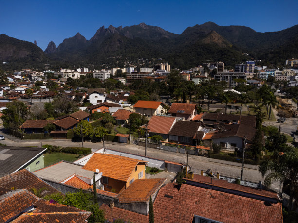 城市的鸟瞰图Teresópolis。在巴西里约热内卢的山区，有蓝色的天空和许多房子。无人驾驶飞机的照片。苏茜,Teresopolis。阳光明媚的一天。日出图片下载
