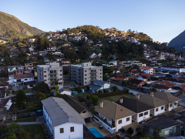 城市的鸟瞰图Teresópolis。在巴西里约热内卢的山区，有蓝色的天空和许多房子。无人驾驶飞机的照片。苏茜,Teresopolis。阳光明媚的一天。日落图片下载