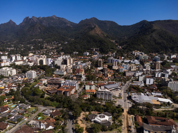 城市的鸟瞰图Teresópolis。在巴西里约热内卢的山区，有蓝色的天空和许多房子。无人驾驶飞机的照片。苏茜,Teresopolis。阳光明媚的一天。日出图片下载