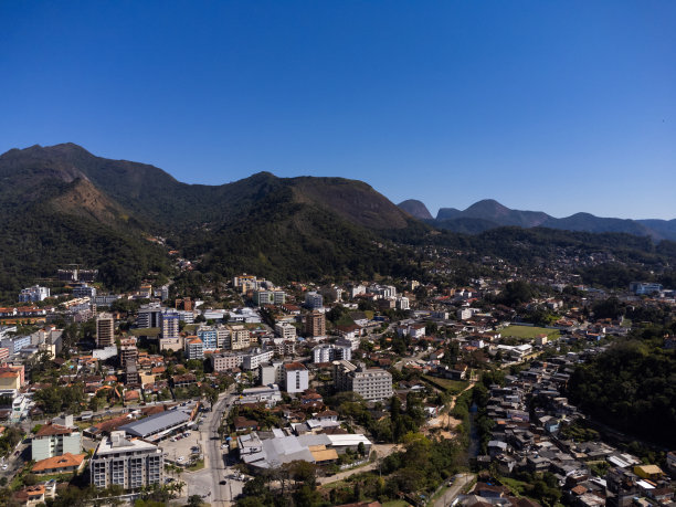 城市的鸟瞰图Teresópolis。在巴西里约热内卢的山区，有蓝色的天空和许多房子。无人驾驶飞机的照片。苏茜,Teresopolis。阳光明媚的一天。日出图片下载