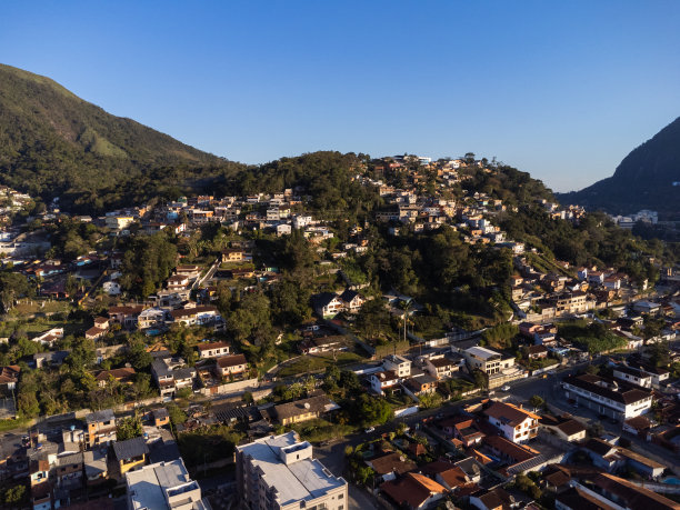 城市的鸟瞰图Teresópolis。在巴西里约热内卢的山区，有蓝色的天空和许多房子。无人驾驶飞机的照片。苏茜,Teresopolis。阳光明媚的一天。日落图片下载
