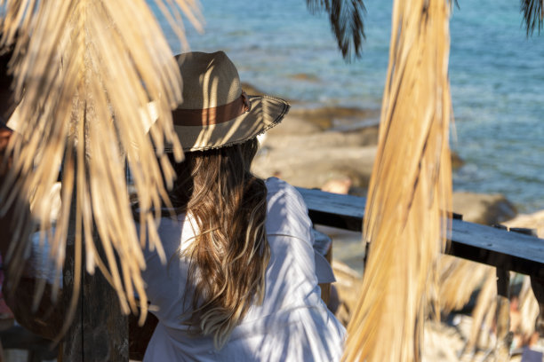 快乐的女人享受在海滩咖啡馆放松快乐的热带蓝色的水。图片下载