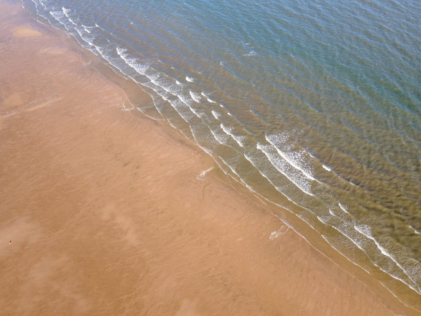 鸟瞰金色沙滩海岸线和浪花图片下载