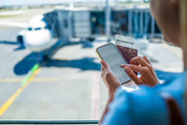 一名年轻女子在机场用手机图片下载