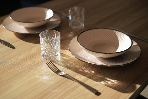 木制餐桌上的玻璃和盘子图片下载