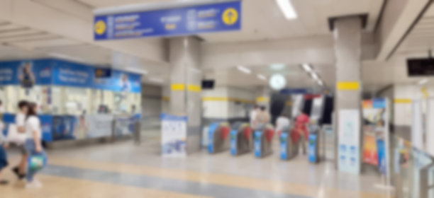 模糊的地铁入口大门在曼谷，泰国。亚洲乘客正戴着止血带前往站台。从旋转门进入火车站。图片下载