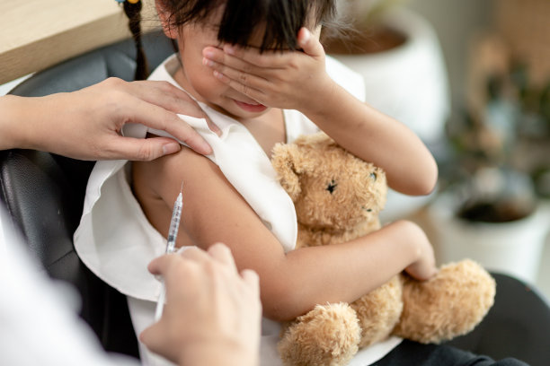 接种疫苗的概念。女医生在诊所给可爱的小女孩接种疫苗图片下载