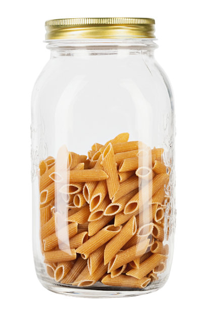 全谷物通心粉从硬粒小麦在瓶子中孤立在白色背景。健康饮食的概念。通心粉Rigate。图片下载