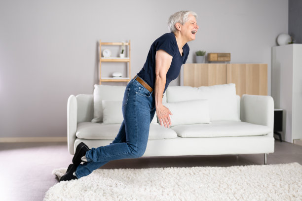 女人在地毯上绊倒意外摔倒图片下载