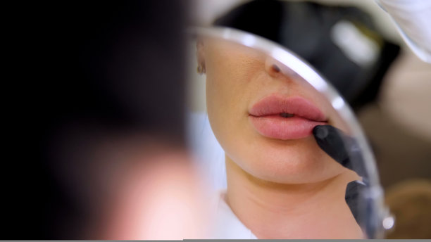 医务室，美女照镜子，医生探头病人的嘴唇后，向嘴唇注射玻尿酸，矫正嘴唇的形状。图片下载