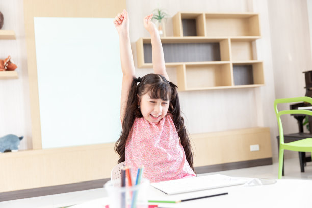 快乐微笑的年轻亚洲学生学生女孩用彩色铅笔做作业后，校园或学校在客厅学习图片下载