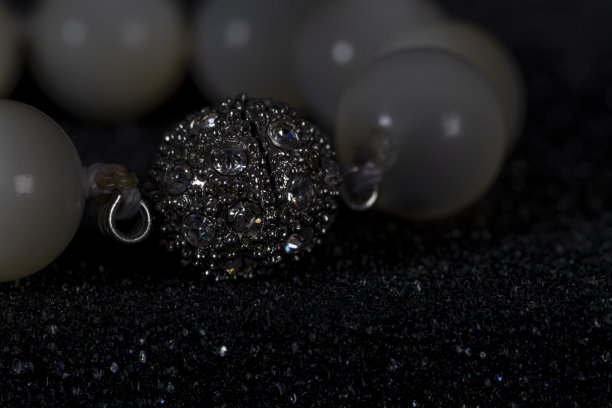 珍珠项链微距照片上的黑色背景闪亮的粒子图片下载