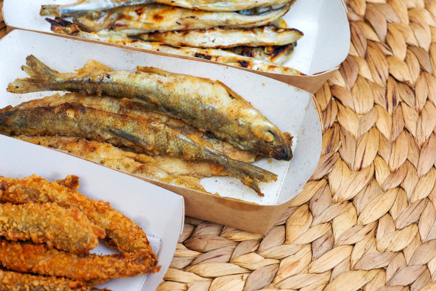 竹席上的香鱼，面粉和香料混合炸脆鱼，用热油炸，街头小吃图片下载