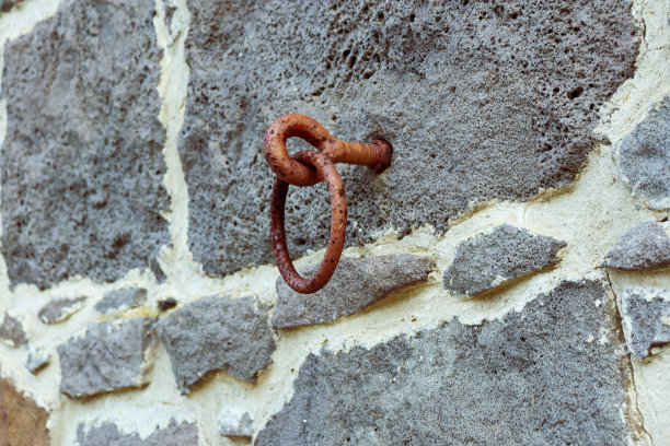 老石墙上生锈的钩子图片下载