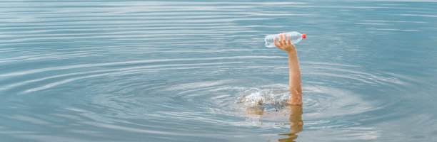 举起手捧瓶的塑料垃圾海滩污染水环境和塑料概念。节约海洋塑料污染。清理垃圾的水。空瓶手成功自然污染概念图片下载