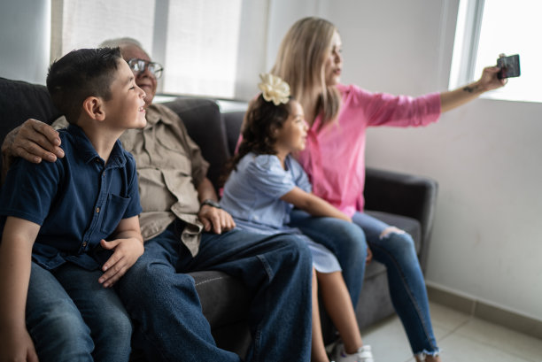 多代家庭在家里用手机自拍图片下载