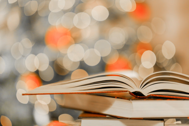堆叠的书在桌子上闪光闪烁的花环的背景。冬日里舒适的阅读。圣诞故事，故事，神话和传说。寒假阅读图片下载