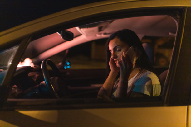 沮丧的年轻女子坐在车里玩手机图片下载