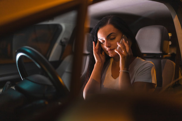 压力大的年轻女子坐在路边的车里打电话图片下载