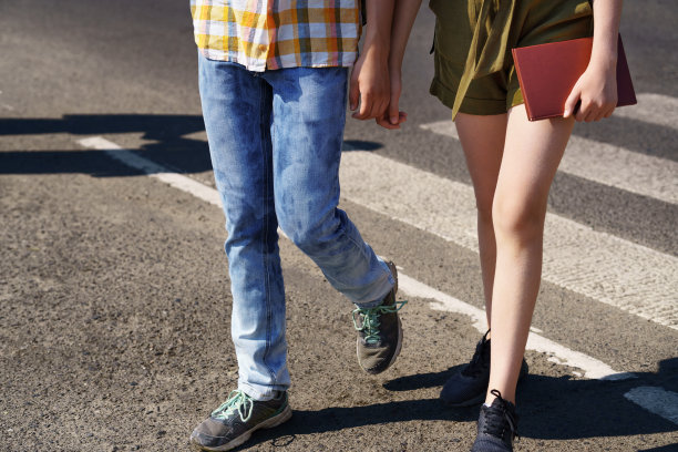 十几岁的学童，一个男孩和一个女孩在人行横道过马路图片下载