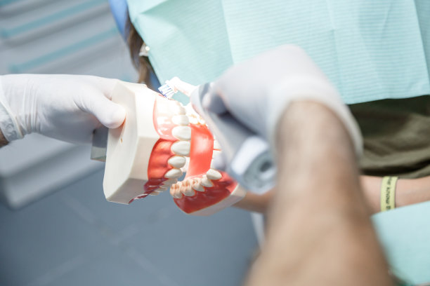 牙科医生向病人展示清洁牙齿的技巧图片下载