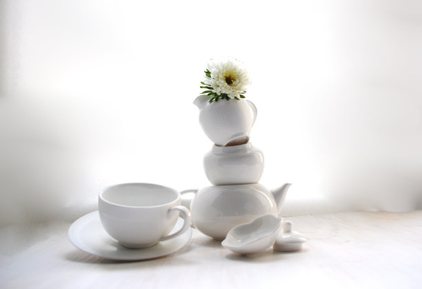 空的白色茶杯，茶托，茶壶，牛奶杯，糖壶和紫菀花在上面图片下载