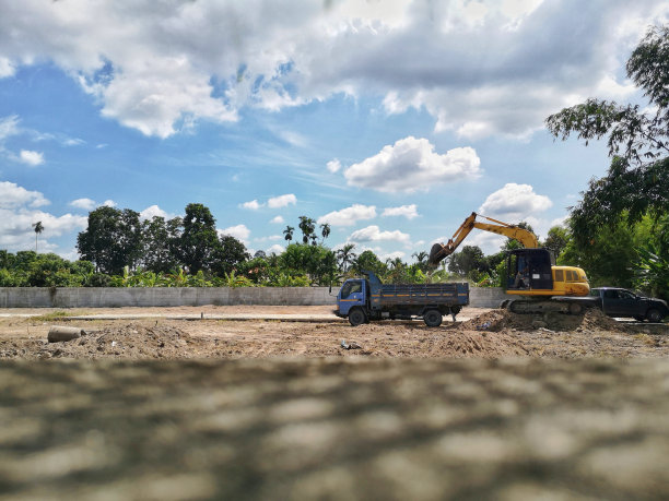 黄土挖掘机正在把土铲进卡车。图片下载