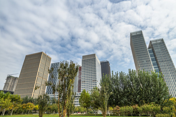 绿色的树木前面现代化的玻璃办公大楼图片下载