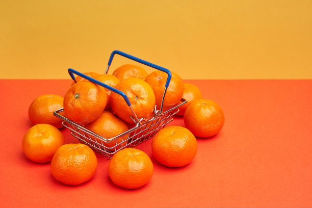 在明亮的背景下，超市购物篮里美味的成熟橘子图片下载