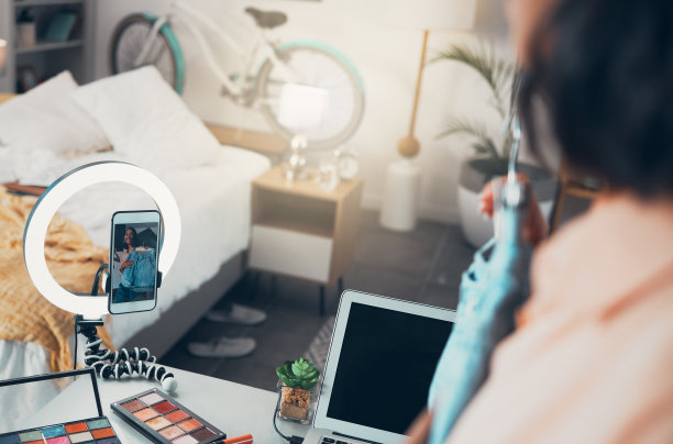 时尚网红、时尚视频博主或社交媒体企业家用手机在线直播内容。时髦的自由职业者录制或发布视频到她的频道为观众和订阅者图片下载