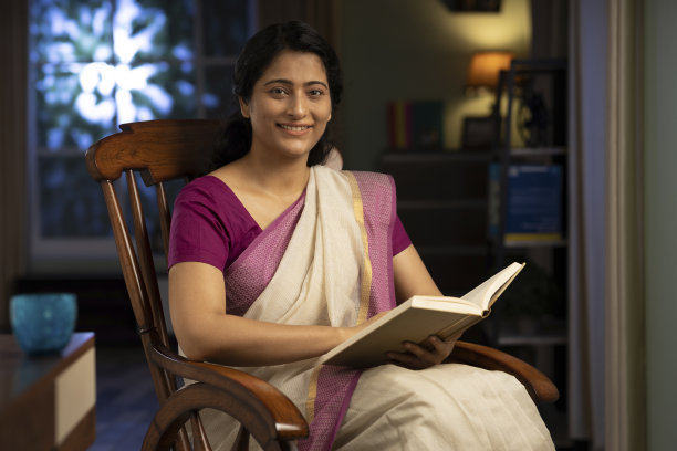 美丽成熟的女人在摇椅上读书，股票照片图片下载