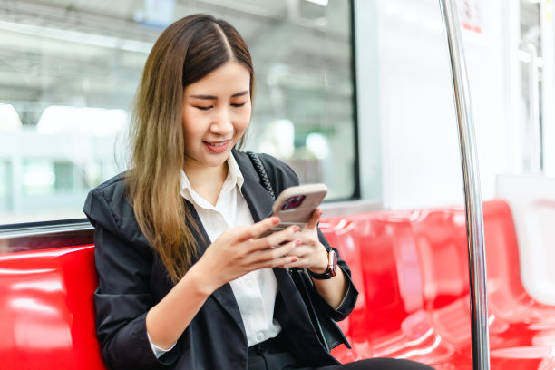 亚洲职业女商人在智能手机上打字，查看社交媒体动态。图片下载