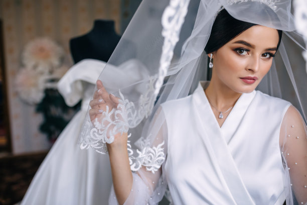 穿着浴袍的新娘特写肖像。一个欧洲人模样的年轻女孩，在闺房里化妆、发型、戴面纱图片下载