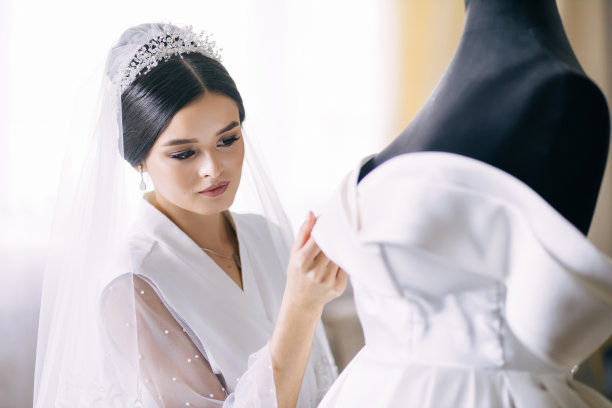 美丽的黑发新娘身穿晨衣，身穿白色婚纱，身穿人体模型图片下载