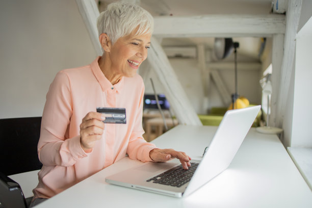 一名女子用信用卡和手机在网上购物图片下载