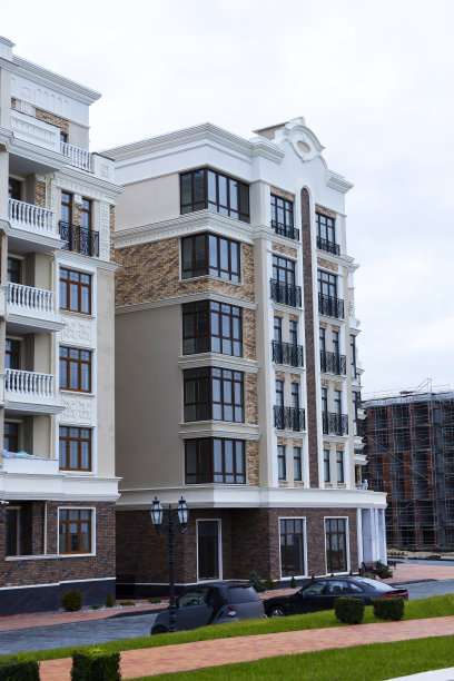 阳光明媚的日子里，蓝天映衬着现代化的公寓楼。图片下载