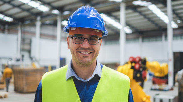 快乐的工程师在机器人设备内工作-新的工业技术概念图片下载