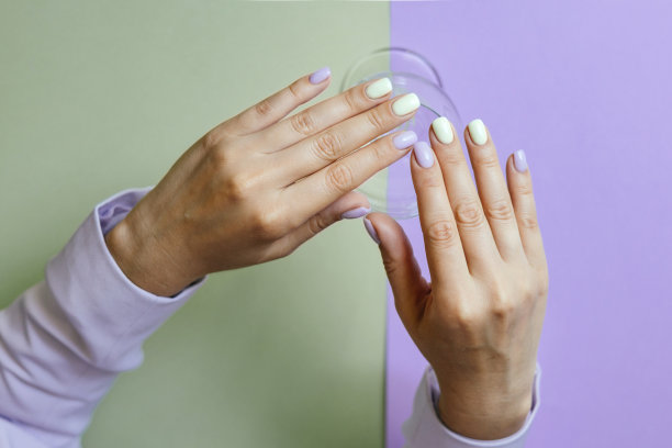 美丽的紫色美甲在乳白色的背景。图片下载