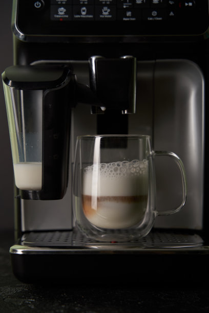 现煮的卡布奇诺从咖啡机中倒入玻璃杯中。图片下载