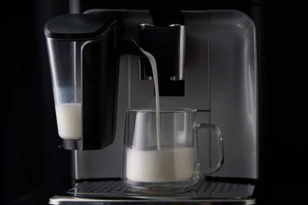 现煮的卡布奇诺从咖啡机中倒入玻璃杯中。图片下载